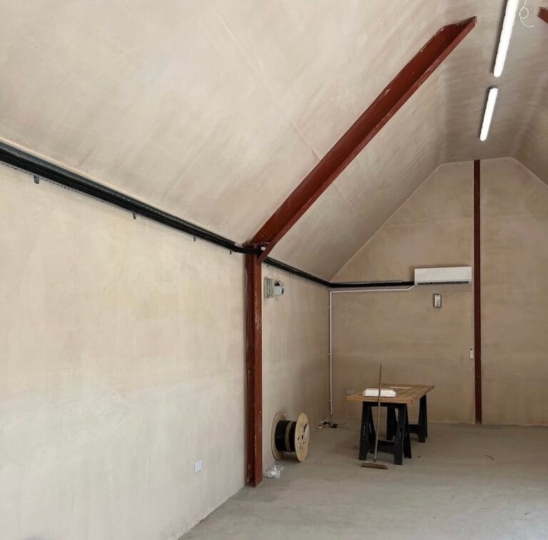 Wide view of a Bosch air conditioning installation in a high-ceiling workshop with neatly routed services