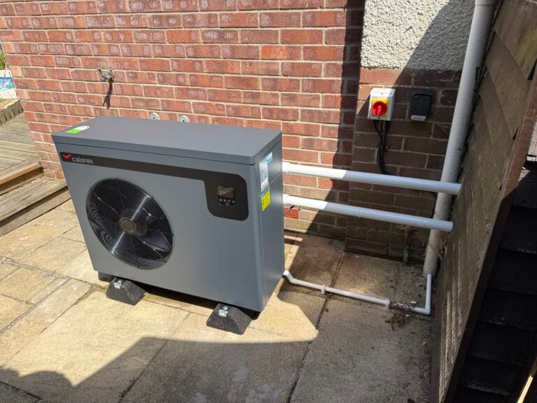 Calorex swimming pool heat pump installed beside a brick property