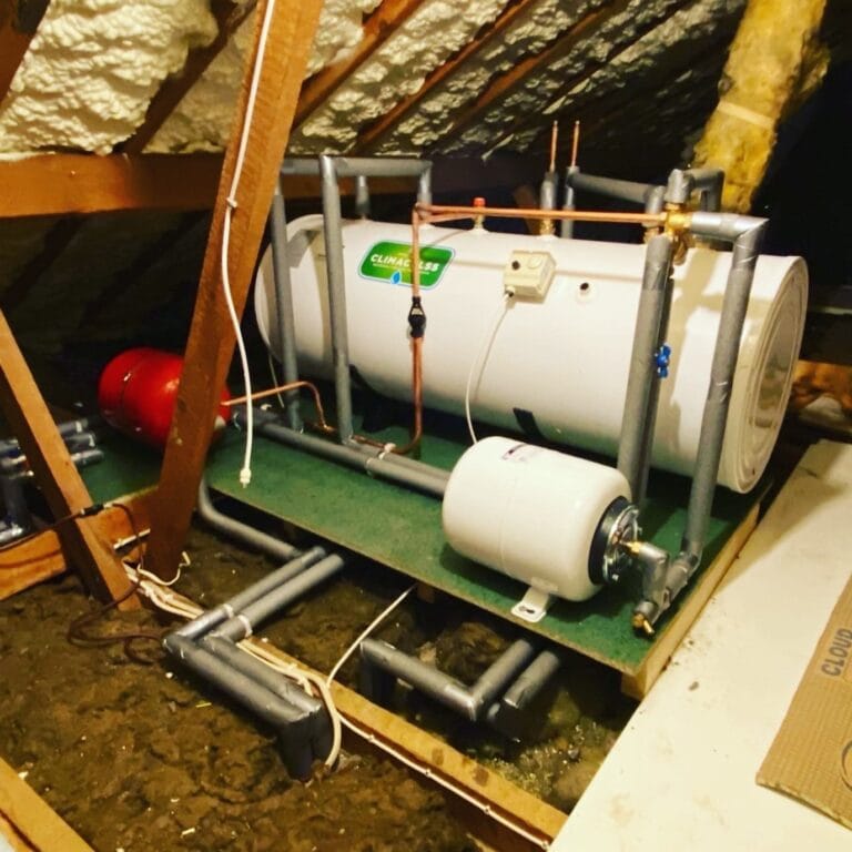 Horizontal unvented hot water cylinder installed in a loft with expansion vessels and insulated pipework