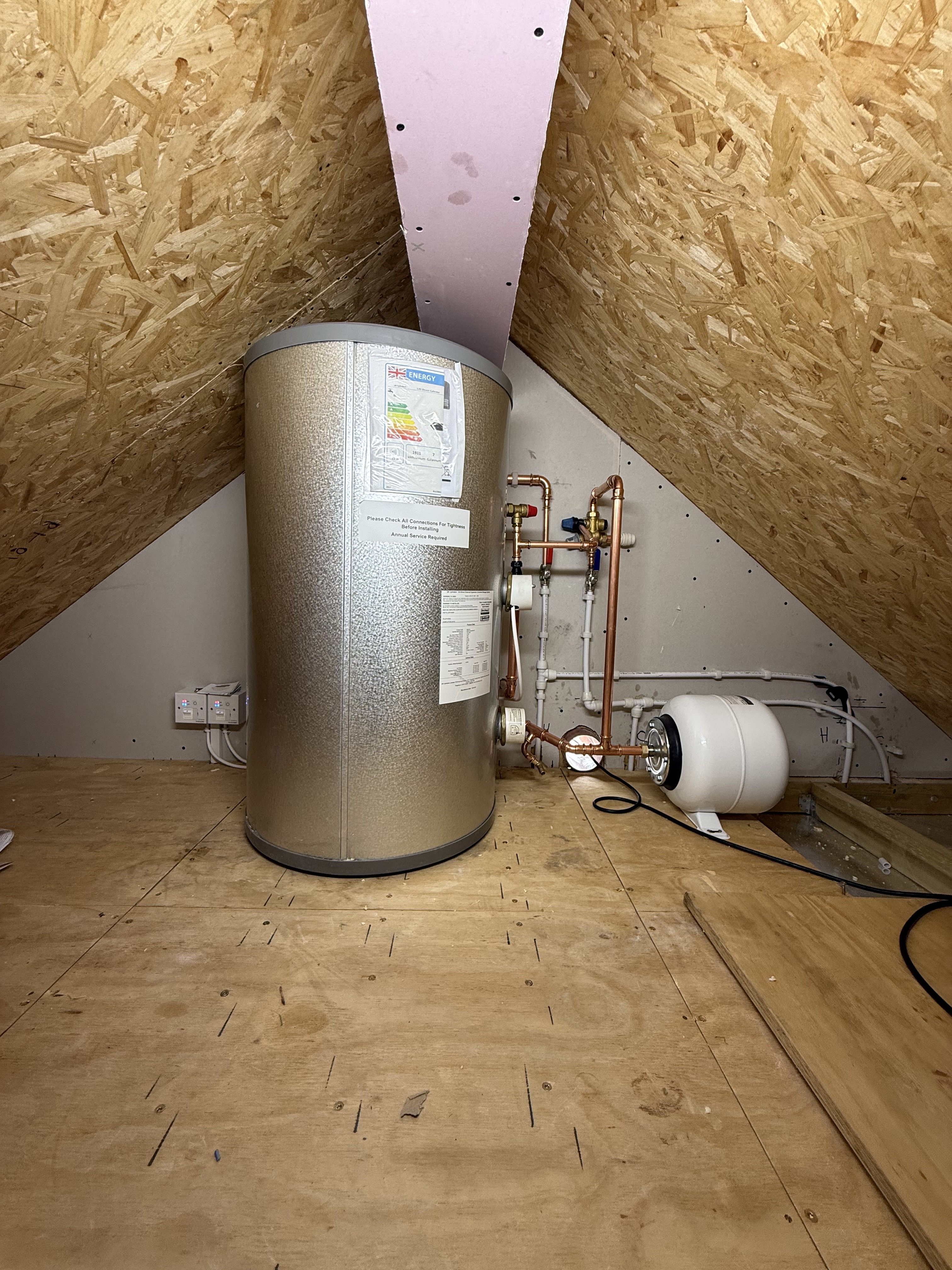 Large insulated hot water cylinder and expansion vessel installed by Oxyplumb in an Oxfordshire loft