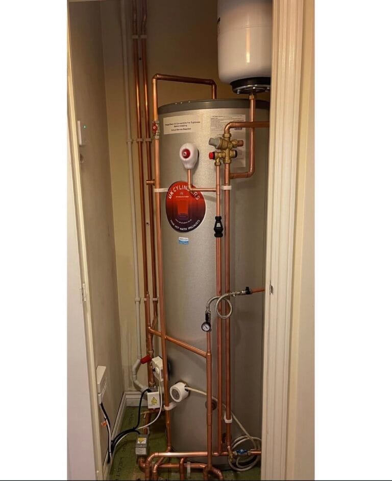 Kingspan unvented hot water cylinder installed in a cupboard with neatly clipped copper pipework and expansion vessel