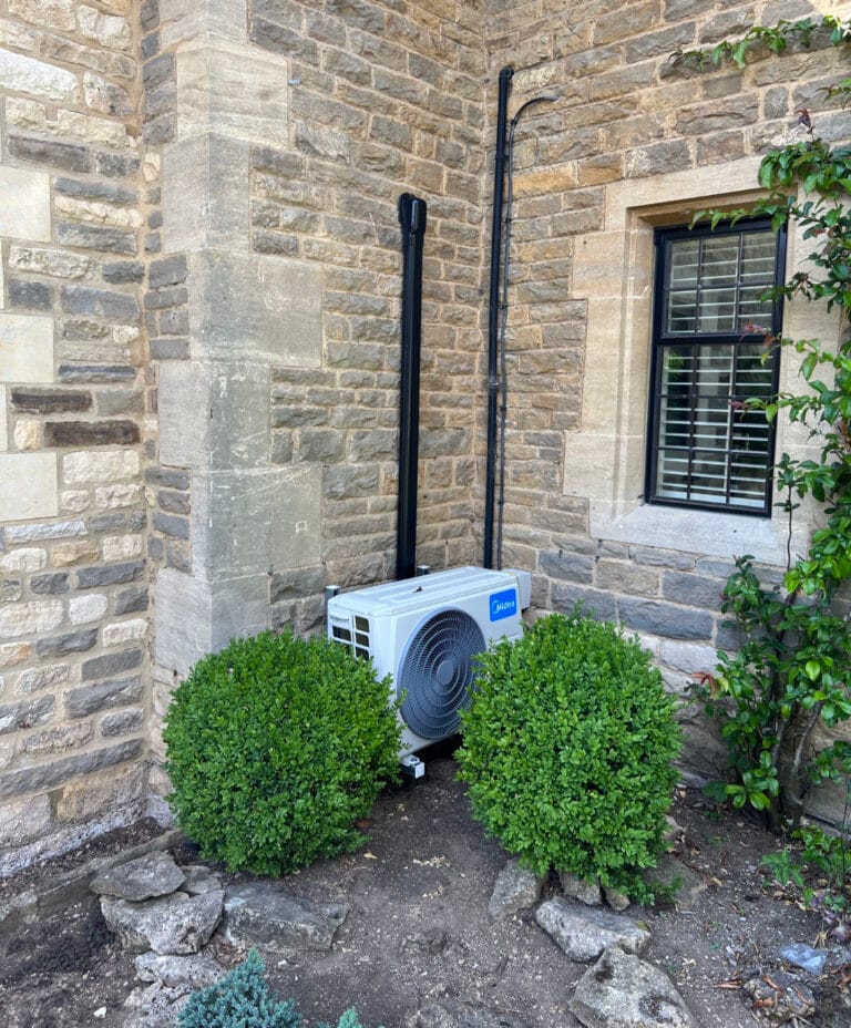Midea outdoor air conditioning unit discreetly installed at a stone property