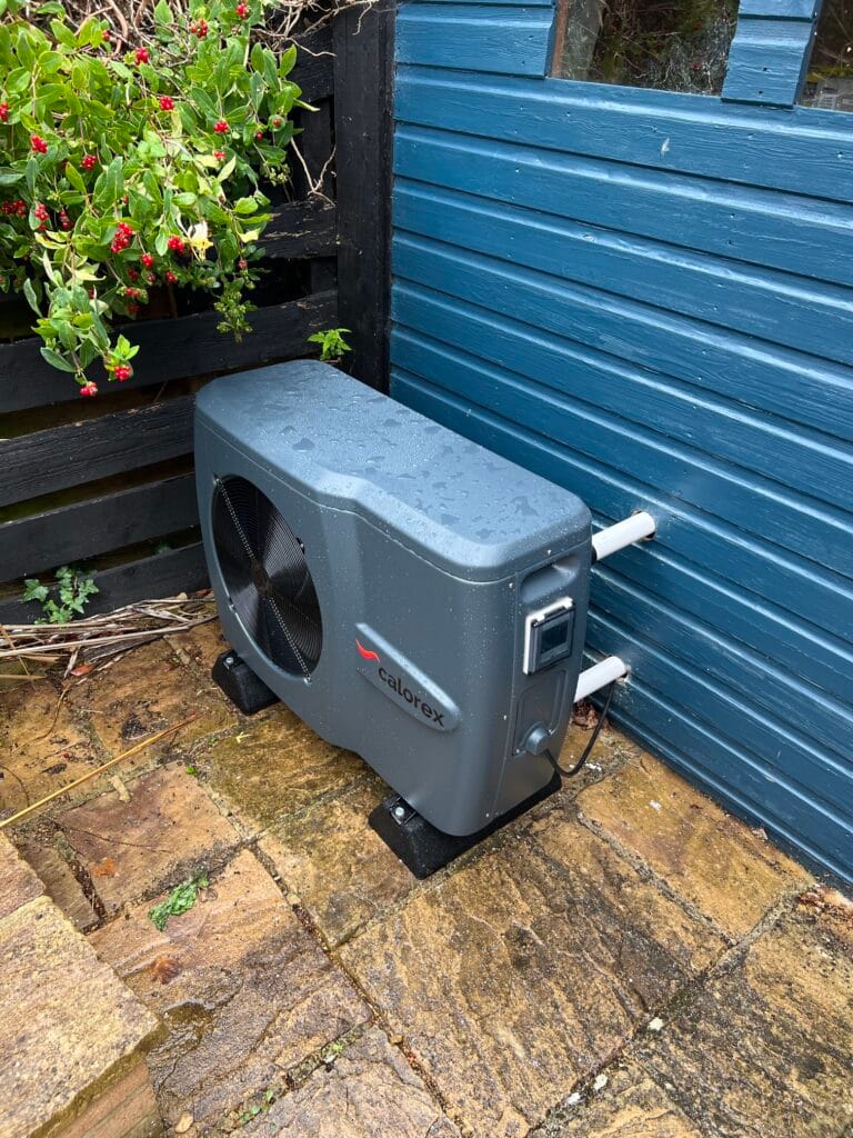 New Calorex swimming-pool heat pump installed beside a timber outbuilding