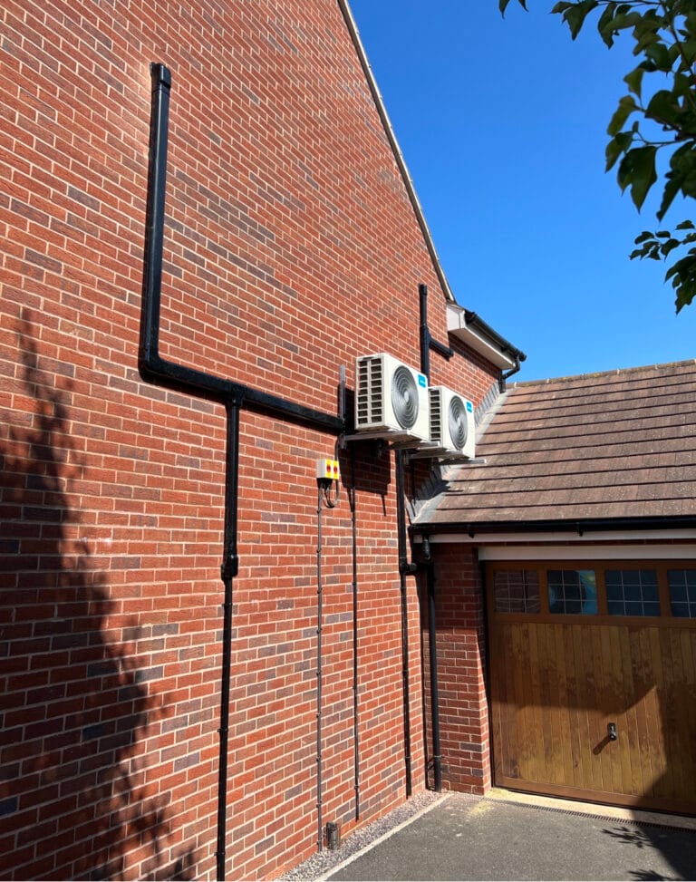 Two Midea outdoor air conditioning units installed on wall brackets