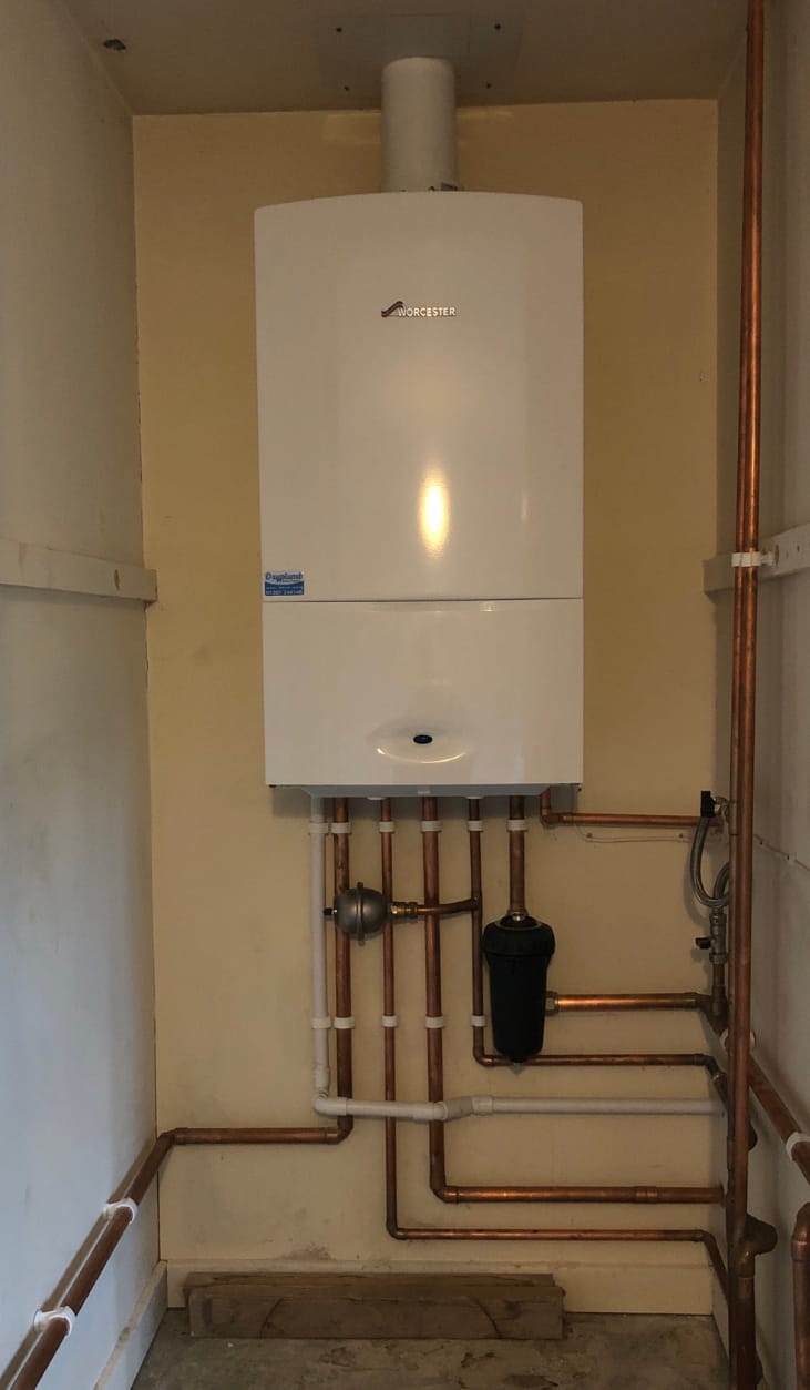 Wall-mounted boiler installed with heating controls and system components