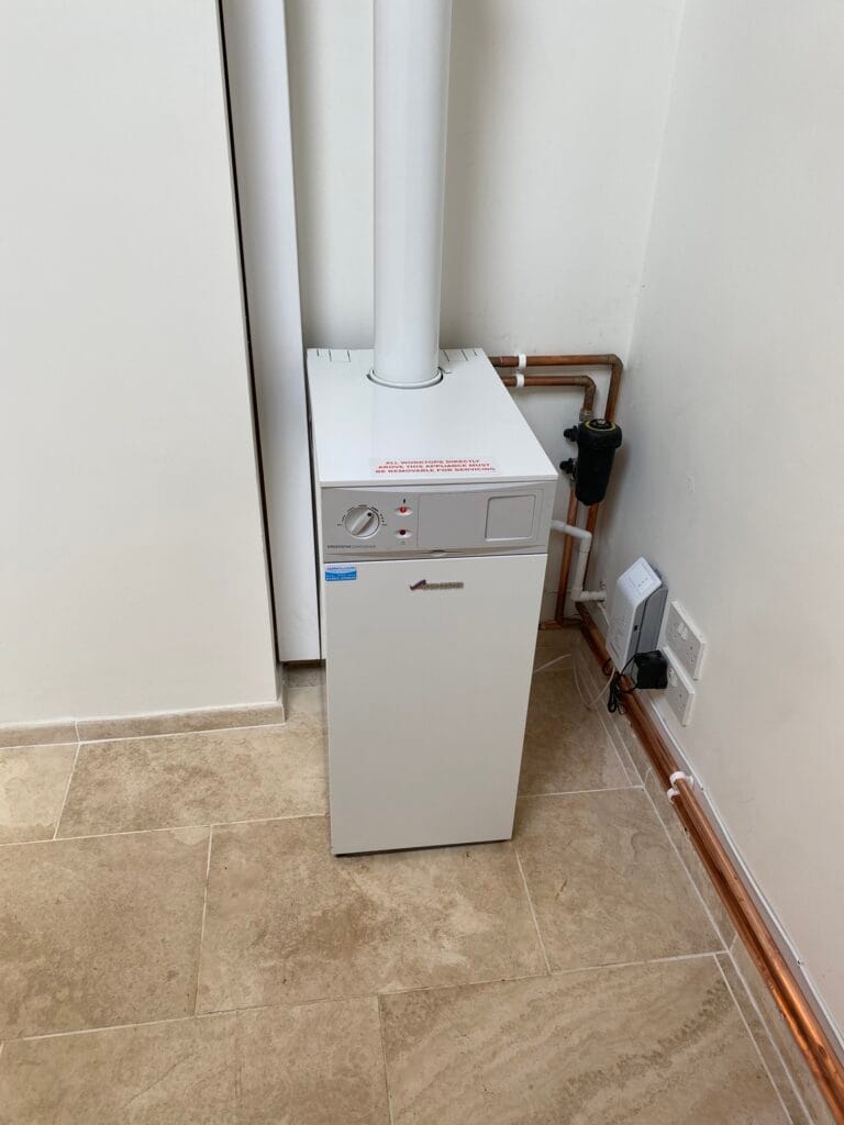 Worcester Bosch floor-standing oil boiler installed with a vertical flue and neatly routed copper pipework